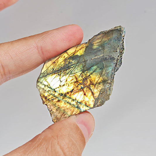 Fragmento de labradorita semi pulida, piedra bruta de color gris con reflejos azules y verdes, de Mystical Tienda.