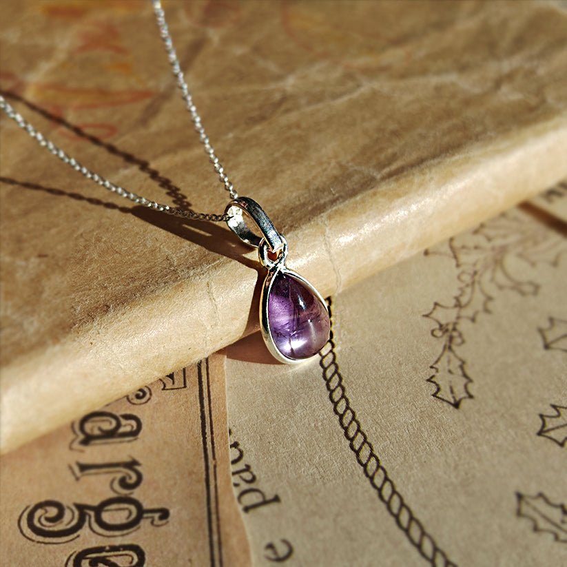 Colgante de plata con amatista en diseño 'Aurora', hecho de plata de ley 925, mostrando detalles de la piedra y el colgante.