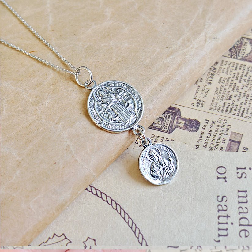 Colgante doble protección San Benito y San Judas Tadeo en plata de ley 925, con detalles religiosos y diseño elegante.