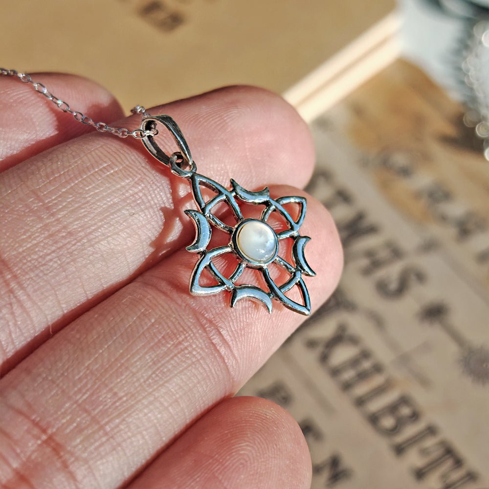 Colgante de plata de ley 925 con nudo de bruja Wicca y nácar, diseñado por Mystical Tienda, en un fondo neutro y brillante.