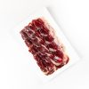 Jamón Sagrada Paleta de Bellota 100% Ibérica de 80g, cortado a cuchillo, presentado en un plato para degustación.