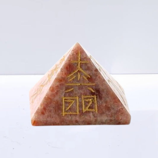 Pirámide Reiki de Piedra de Sol, figura geométrica de cristal color naranja y amarilla, diseñada para prácticas de reiki y meditación.