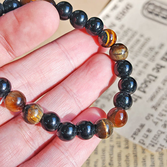 Pulsera de mineral “Limpieza Energética” con ojo de tigre y turmalina, muestra las piedras en una pulsera en tonos naturales.