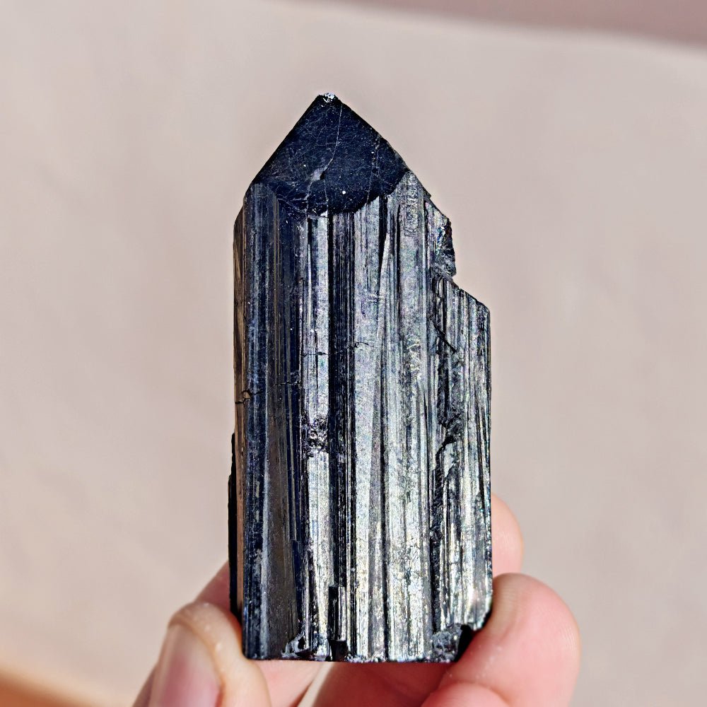 Punta de turmalina negra semipulida de Mystical Tienda, pieza de cristal con forma puntiaguda y superficie pulida negra.