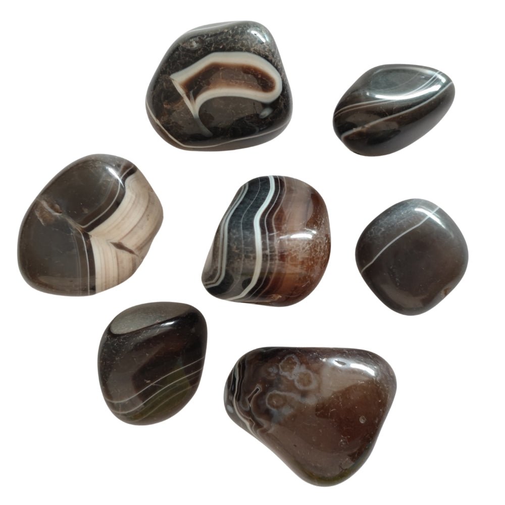 Rodado de Ágata Negra de Mystical Tienda, muestra la superficie pulida y brillante de la piedra natural en un fondo neutro.