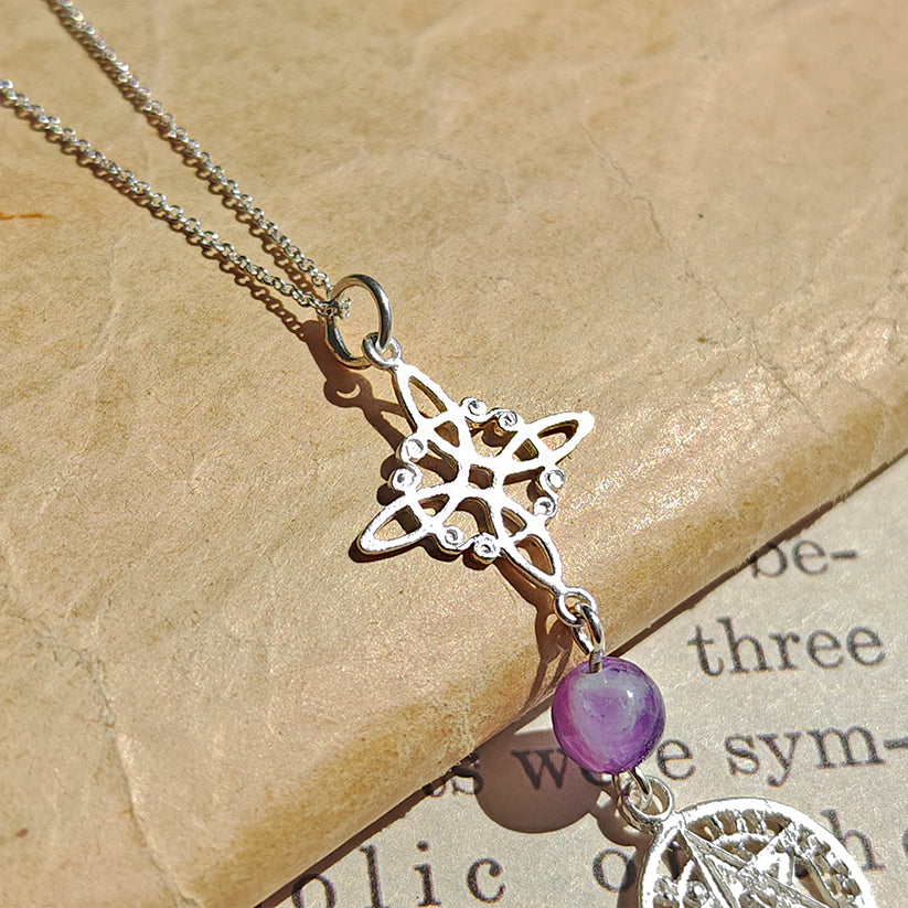 Colgante de plata con nudo de bruja, símbolo tetragramatón y bola de amatista, estilo místico y elegante.