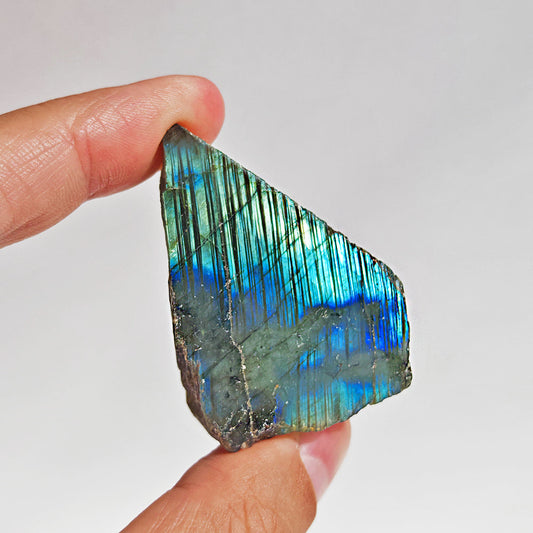 Mineral labradorita semi pulida en bruto, con tonos iridiscentes y textura natural, de la tienda Mystical.