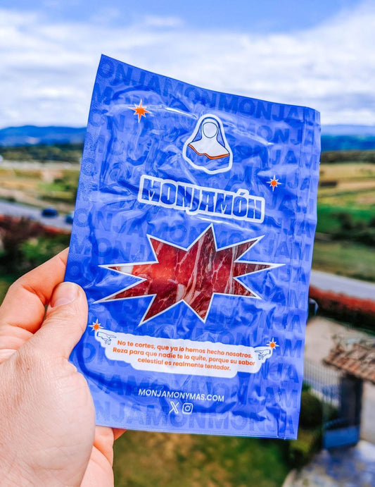 Jamon de paleta ibérica Sagrada Paleta de Bellota 100% Ibérica de MONJAMON Y MAS, presentado en lonchas finas sobre un plato.