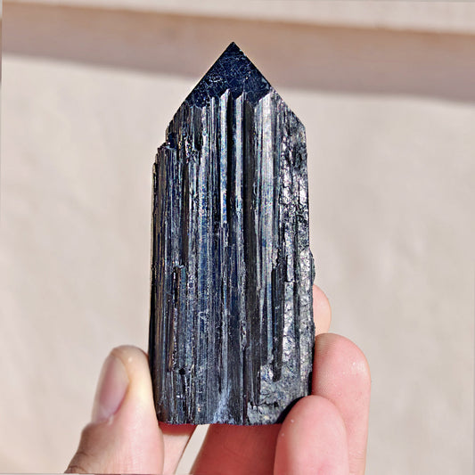 Punta de turmalina negra semipulida de Mystical Tienda, muestra detalles y brillo en la superficie de la piedra.