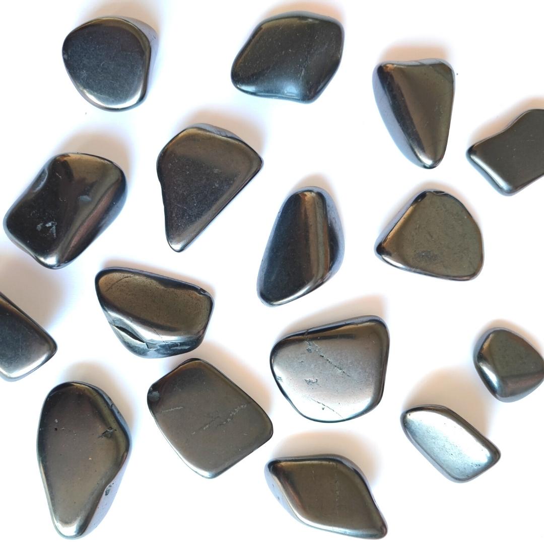 Armonizador de shungit y tulikivi en rodado de Mystical Tienda, muestra las piedras pulidas en un soporte natural y decorativo.