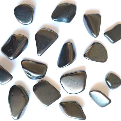 Armonizador de shungit y tulikivi en rodado de Mystical Tienda, muestra las piedras pulidas en un soporte natural y decorativo.