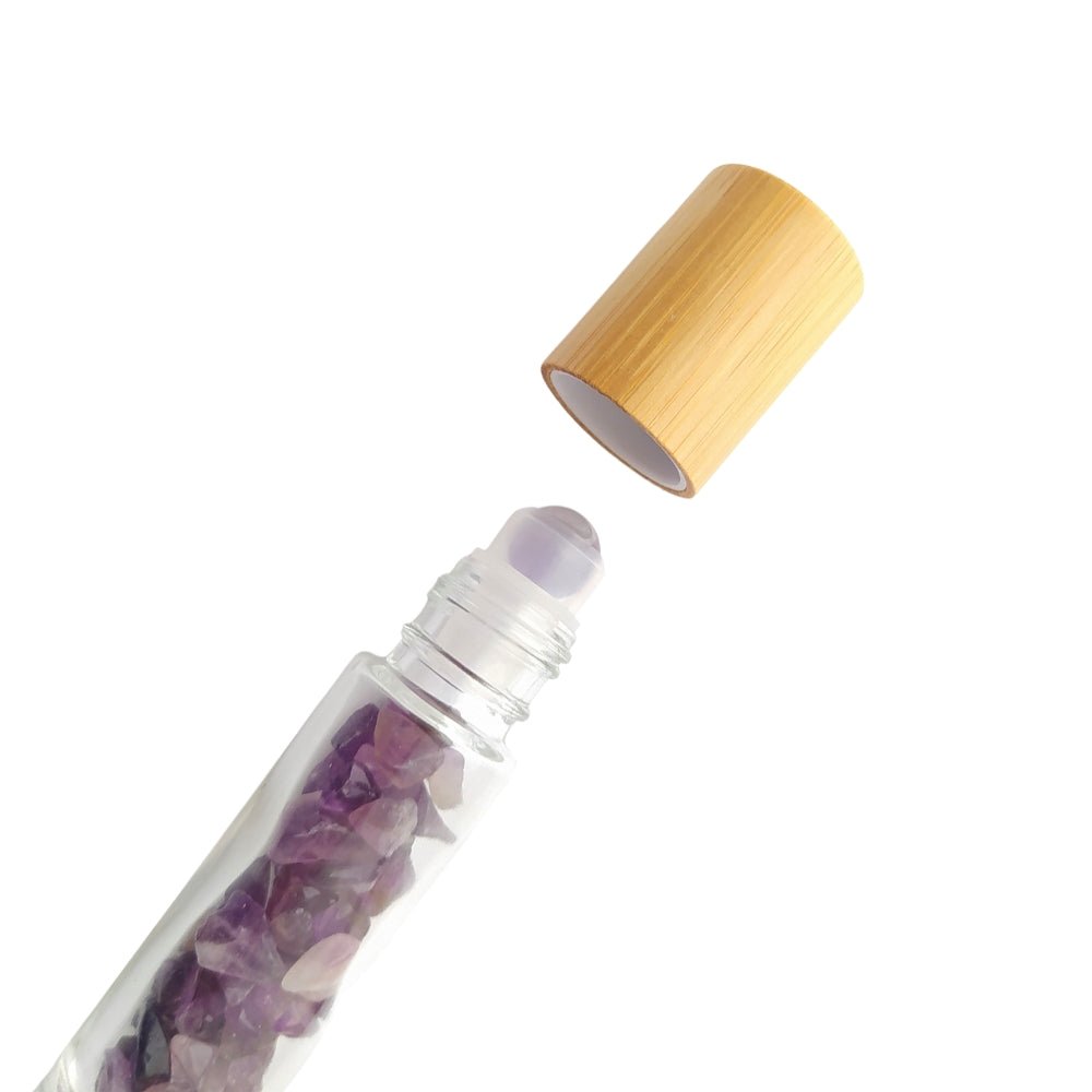 Botella roll-on de amatista de cristal, con chip para aromaterapia, en envase transparente con tapa plateada.