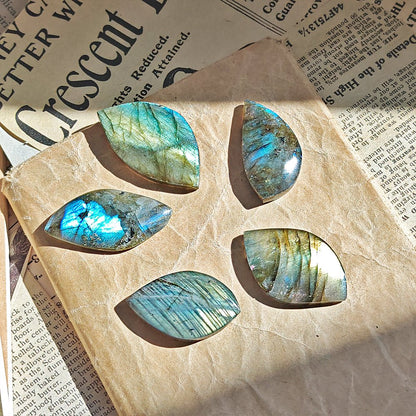 Cabujón de labradorita rodado de Mystical Tienda, con brillo iridiscente y patrones naturales en tonos azules y verdes.