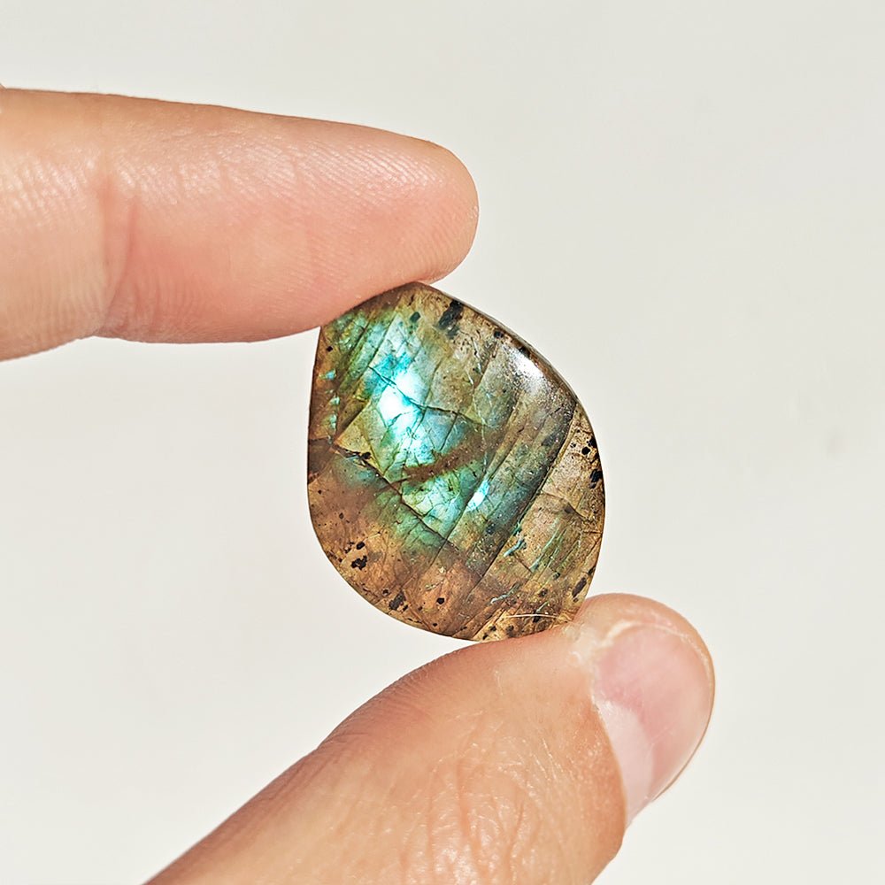 Cabujón rodado de labradorita de Mystical Tienda, muestra reflejos azules y verdes en piedra natural brillante.