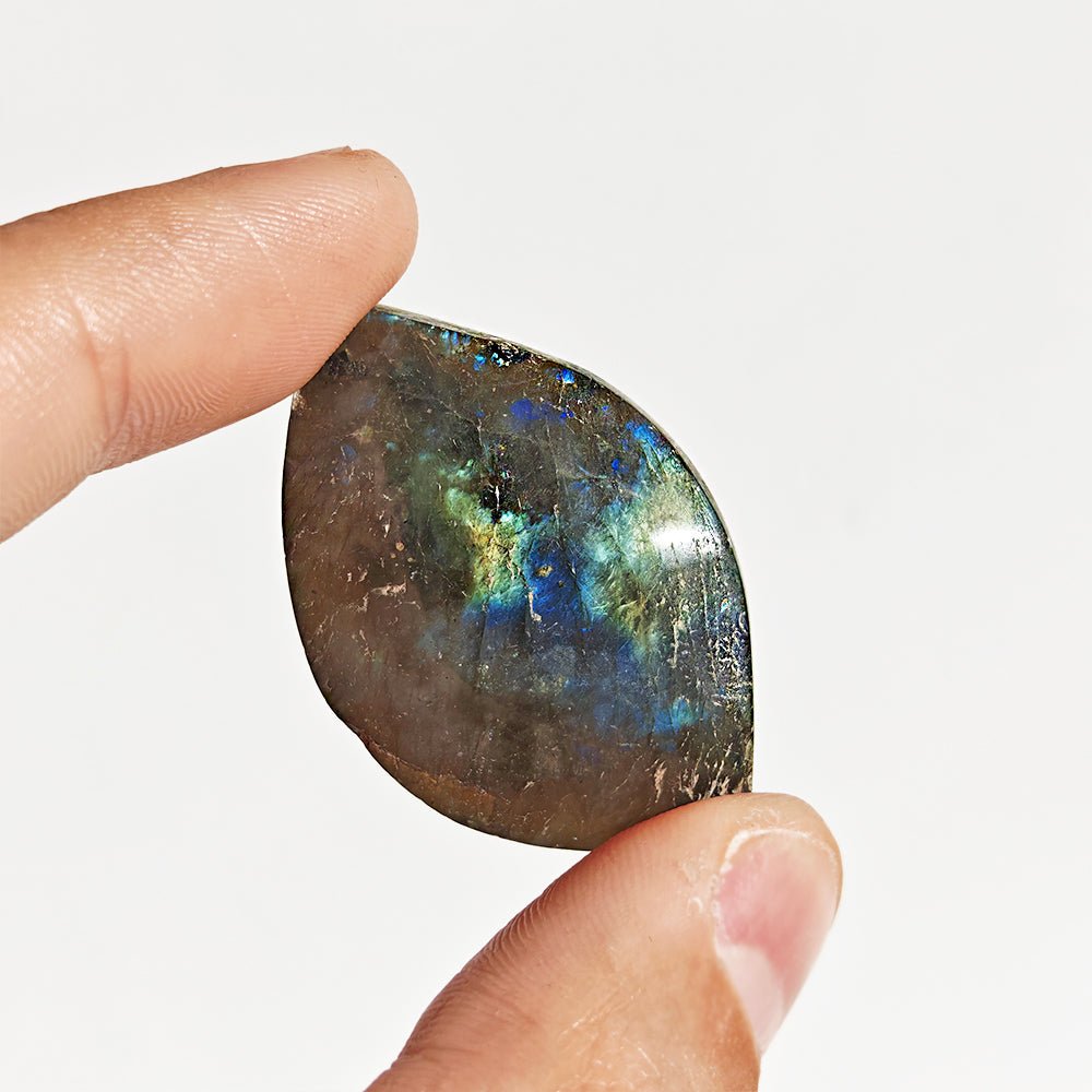 Cabujón rodado de labradorita de la marca Mystical Tienda, mostrando su brillo y colores iridiscentes en la piedra.