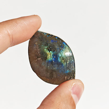 Cabujón rodado de labradorita de la marca Mystical Tienda, mostrando su brillo y colores iridiscentes en la piedra.