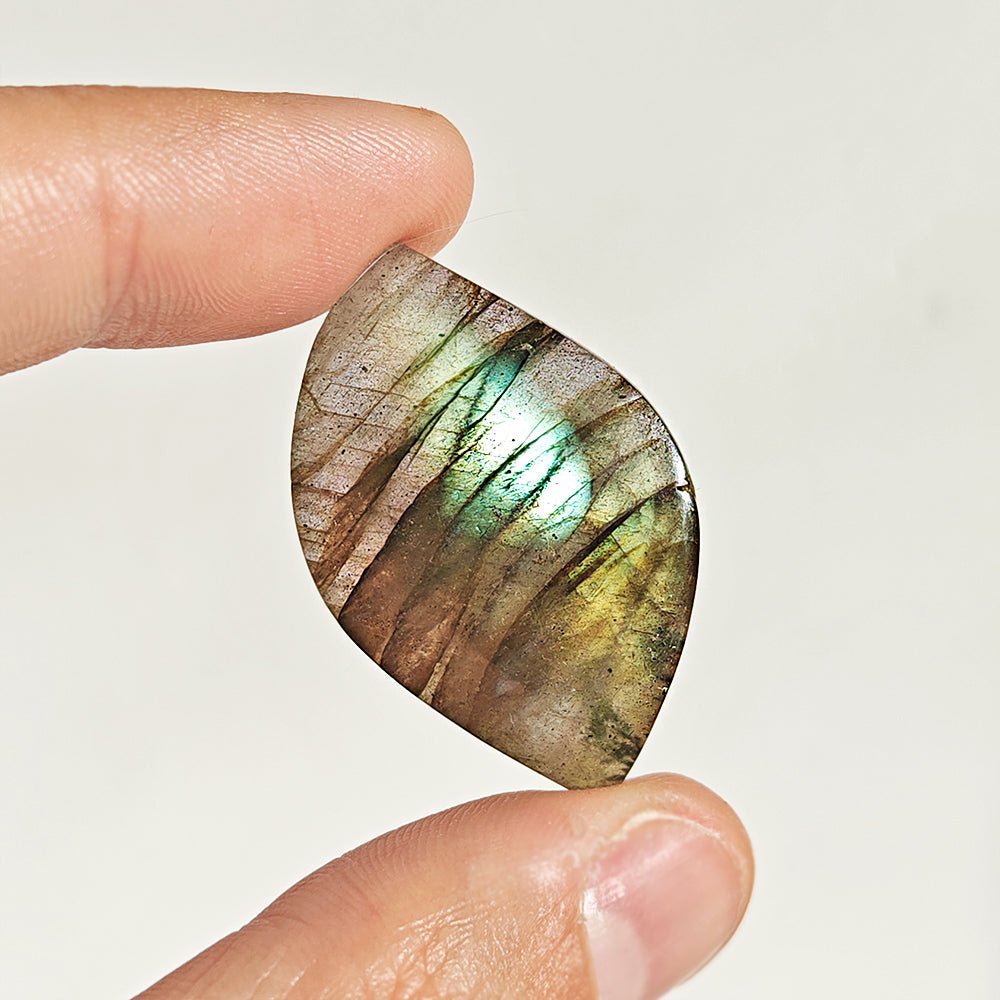 Cabujón de labradorita en forma rodado, muestra sus tonos azules y verdes brillantes, de la marca Mystical Tienda.