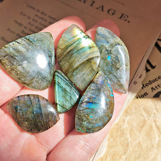 Cabujón rodado de labradorita de la marca Mystical Tienda, con reflejos azules y verdes en superficie de piedra natural.