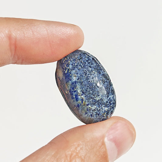 Cabujón plano de Lapislázuli de la marca Mystical Tienda, mostrando la piedra azul con vetas doradas en un fondo neutro.
