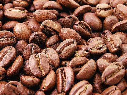 Café diferenciado Bourbon Rosado de Irrúa Café, proceso Honey, granos de café en taza con aroma y color dorado.