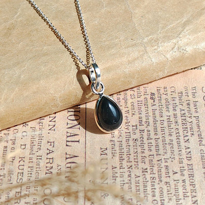 Colgante de plata de ley 925 con ónix negro y diseño inspirado en la Aurora, artesanal y elegante.