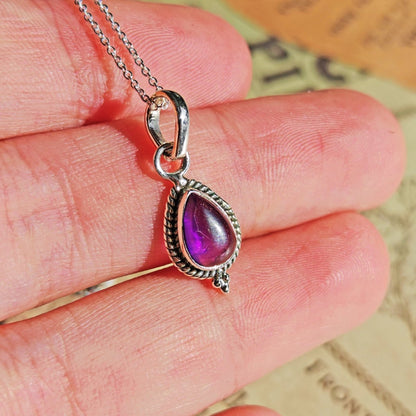 Colgante Dewi de amatista y plata de ley 925, joya elegante con piedra púrpura, en un fondo neutro.