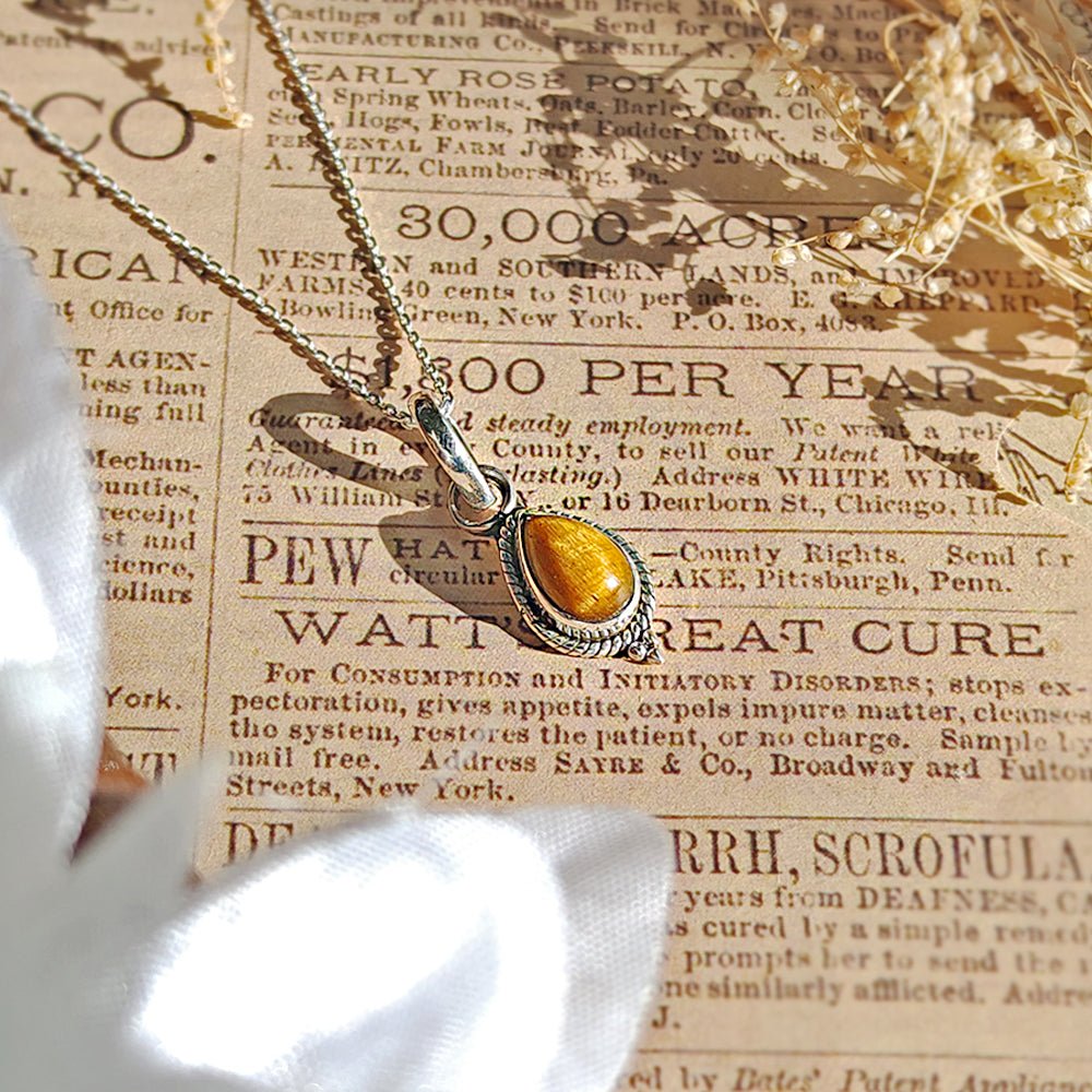 Colgante de plata de ley 925 con piedra ojo de tigre y diseño inspirado en Dewi, estilo elegante y místico.