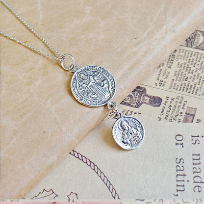 Colgante doble protección San Benito y San Judas Tadeo en plata de ley 925, con detalles religiosos y diseño elegante.