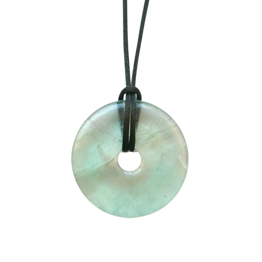 Colgante de mineral Donut de Fluorita Verde de Mystical Tienda, muestra la piedra en forma de donut con tonos verdes vibrantes.