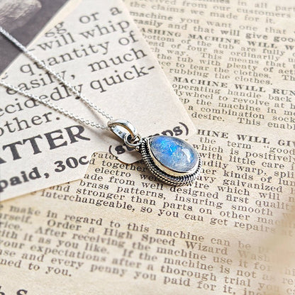 Colgante de plata de ley 925 con piedra de luna y diseño Hina, joya elegante y mística en tonos plateados y azul claro