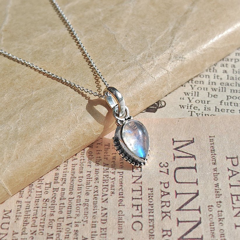 Colgante de plata de ley 925 con piedra de luna y diseño inspirado en Ishtar, sobre fondo neutro.