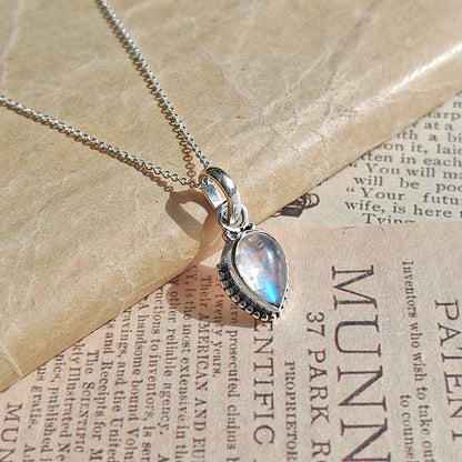 Colgante de plata de ley 925 con piedra de luna y diseño inspirado en Ishtar, sobre fondo neutro.