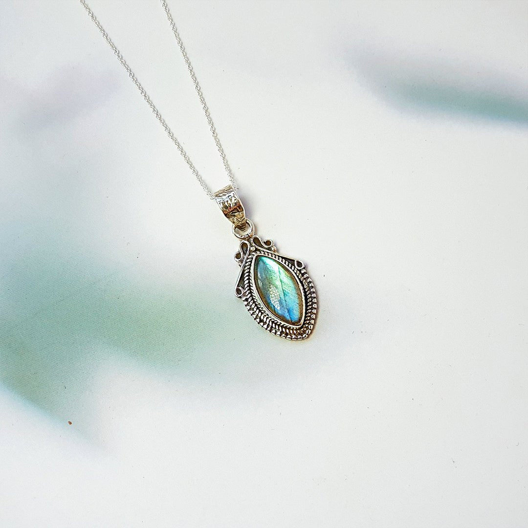 Colgante de lágrima con piedra de labradorita y plata de ley 925, diseño elegante y delicado en color gris y azul.
