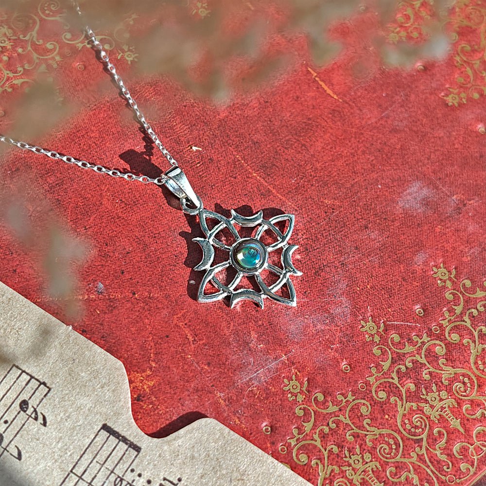 Colgante de plata de ley 925 con nudo de bruja Wicca y abulón, muestra detalles finos y diseño místico.