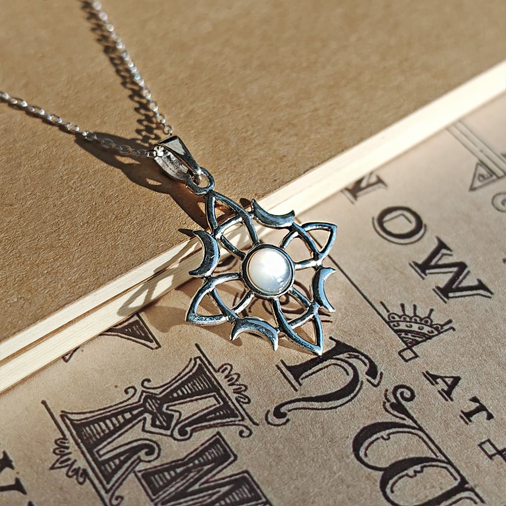 Colgante de plata de ley 925 con nudo de bruja Wicca y nácar, diseño místico y elegante.