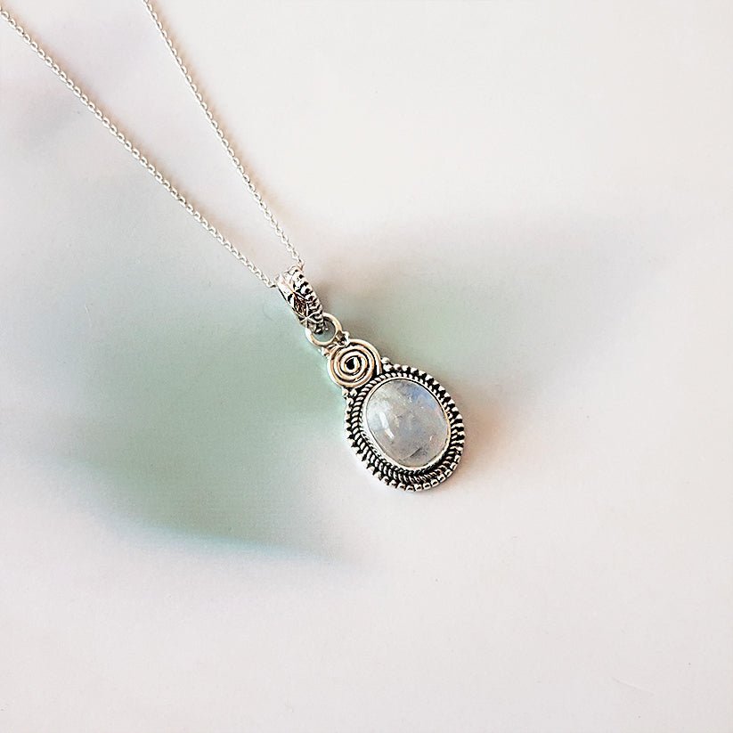Colgante de plata de ley 925 con piedra de luna en forma ovalada, diseño espiral, joyería elegante y natural.