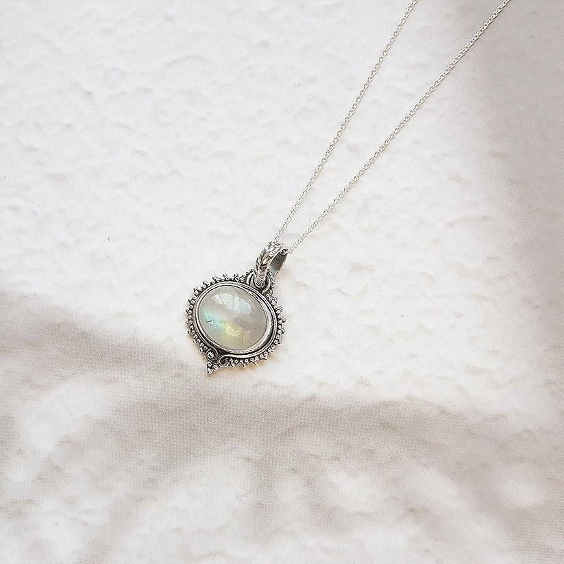 Colgante de plata de ley 925 con piedra de luna, estilo Amisha, diseño elegante y detallado, sobre fondo neutro.