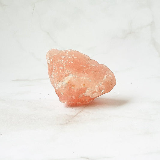 Cuarzo rosa en bruto de Mystical Tienda, piedra natural sin pulir con cristales rosados y textura irregular.