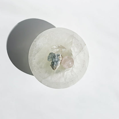Cuenco de selenita para altar, muestra detalles de la piedra blanca y transparente en un entorno espiritual.