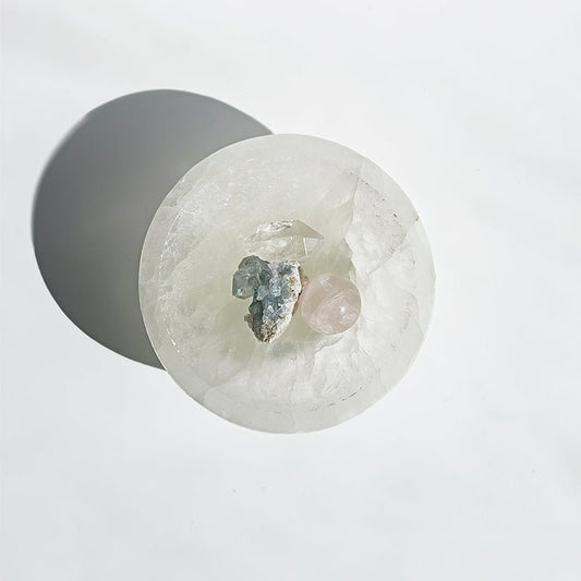 Cuenco de selenita para altar, muestra detalles de la piedra blanca y transparente en un entorno espiritual.