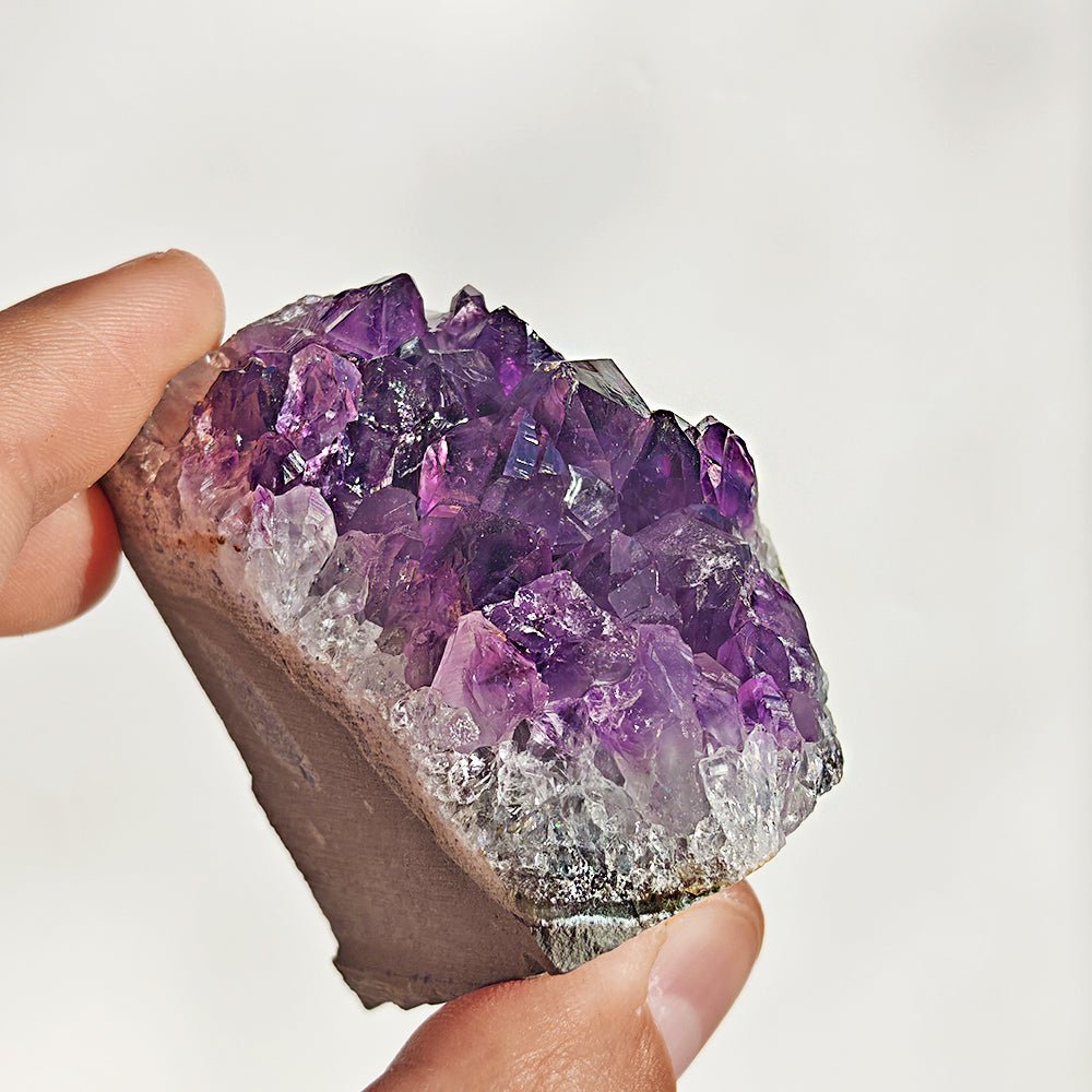 Drusa de amatista con base plana de cristales violetas, muestra detalles y textura natural en una imagen clara y nítida.