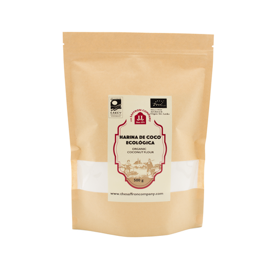 Harina de coco en polvo ecológica de la marca The Saffron Company JJ, vista en un recipiente blanco sobre fondo neutro