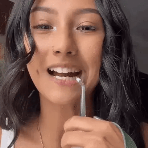 Irrigador dental portátil recargable para toda la familia, mostrando boquilla y diseño compacto en color blanco y azul.