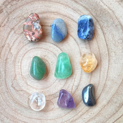 Kit de minerales para estudiar de Mystical Tienda con varias gemas coloridas y cristales en un fondo blanco.