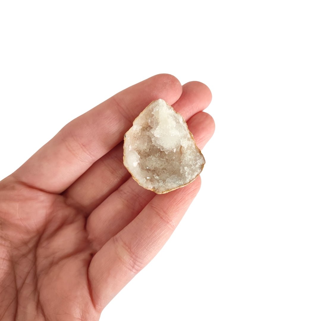 Mitad de geoda de cuarzo blanco con cristales transparentes y estructura natural, ideal para decoración y colección.
