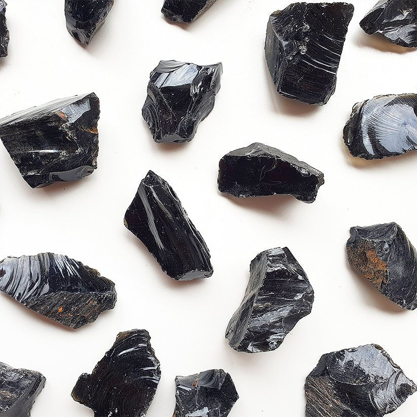 Muestra de obsidiana en bruto, piedra natural negra sin tratar, de la tienda Mystical Tienda, con textura y forma irregular.
