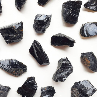 Muestra de obsidiana en bruto, piedra natural negra sin tratar, de la tienda Mystical Tienda, con textura y forma irregular.