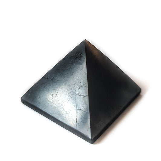 Pirámide de shungit pulida de Mystical Tienda, muestra la superficie lisa y oscura de la piedra mineral.