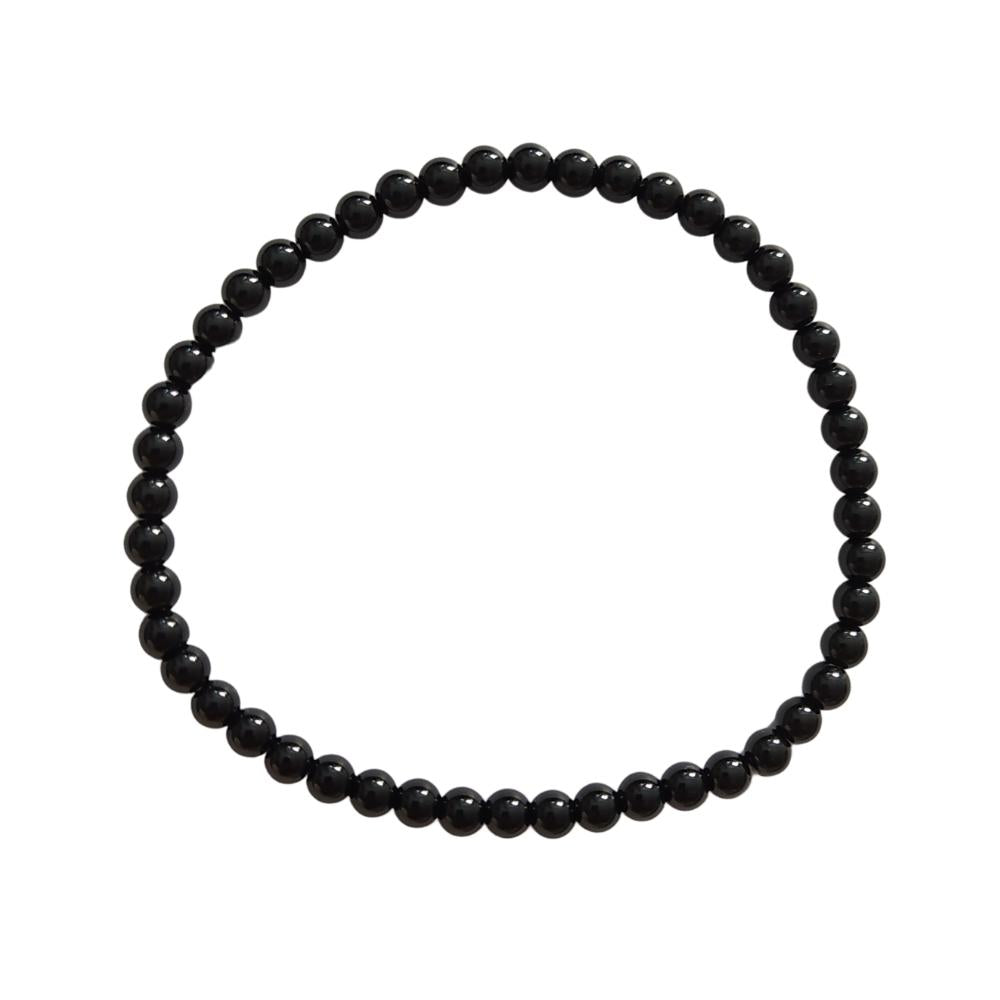 Pulsera de mineral ónix con bolas lisas, fabricada por Mystical Tienda, mostrando las piedras negras y redondas.