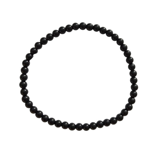 Pulsera de mineral ónix con bolas lisas, fabricada por Mystical Tienda, mostrando las piedras negras y redondas.
